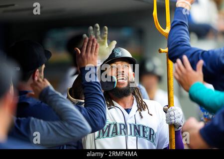 Seattle Mariners' Teoscar Hernandez holds a trident in the dugout