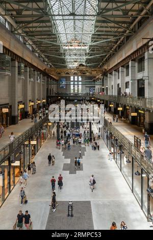 Turbine Hall A of the redeveloped & Grade II* listed Battersea Power Station with many visitors and shoppers filling the shopping centre. London Stock Photo
