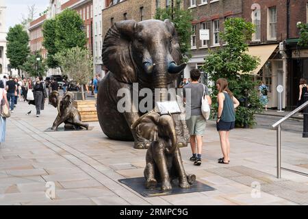 Herd of Hope - a family of life size bronze elephants roaming in Spitalfields Market, London. Each elephant represents an orphaned elephant in Kenya. Stock Photo