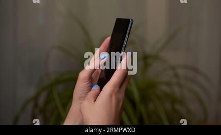 Womans hands is using smartphone, writing a message, browsing social networks. Technologies for life and work. Stock Photo