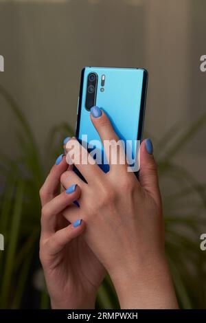 Womans hands is using smartphone, writing a message, browsing social networks. Technologies for life and work. Stock Photo