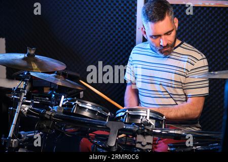 Drummer man playing drums in a recording studio. Music production. Stock Photo