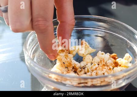 Female Hand Taking Popcorn Out Of A Glas Bowl Stock Photo