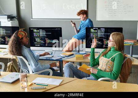 Group of students sitting at desk with computers during IT lesson in the classroom Stock Photo