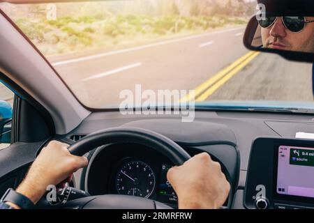 Man driving on the highway, hands on the steering wheel, view from inside of the car Stock Photo