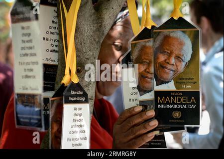 A woman poses for a picture with tags featuring Mandela s portrait during a ceremony commemorating Nelson Mandela International Day, in front of the UN headquarters in New York, on July 18, 2014. (Xinhua/Niu Xiaolei) UN-NEW YORK-NELSON MANDELA-COMMEMORATION PUBLICATIONxNOTxINxCHN   a Woman Poses for a Picture With Tags featuring Mandela S Portrait during a Ceremony Commemorating Ting Nelson Mandela International Day in Front of The UN Headquarters in New York ON July 18 2014 XINHUA Niu Xiaolei UN New York Nelson Mandela Commemoration PUBLICATIONxNOTxINxCHN Stock Photo