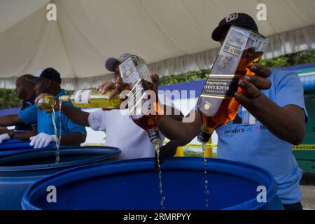 Employees of the Customs General Direction (DGA, for its acronym in Spanish), pour alcoholic beverages after being seized, in Santo Domingo, Dominican Republic, on July 31, 2013. The DGA destroyed on Thursday 2000 boxes of whisky and alcoholic beverages, seized when being entered by contraband on national territory. The 2000 boxes, equivalent to 16,723.13 liters of different types of alcoholic beverages, with an approximate value of 11,793,331.76 dominican pesos, informed the engineer Fernando Fernandez, head of the DGA. Roberto Guzman) (lyi) DOMINICAN REPUBLIC-SANTO DOMINGO-LIQUOR-SEIZURE e R Stock Photo