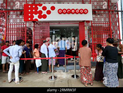 People wait to buy Ooredoo low-priced SIM card outside a SIM cards selling shop in Yangon, Myanmar, Aug. 4, 2014. Ooredoo Myanmar, the local unit of Qatar-based telecom operator, began to sell low-priced SIM cards in three Myanmar cities on Aug. 2 amid the government s efforts to enhance mobile phone coverage in Myanmar. ) MYANMAR-YANGON-OOREDOO-LOW-PRICED SIM CARD UxAung PUBLICATIONxNOTxINxCHN   Celebrities Wait to Buy  Low priced Sim Card outside a Sim Cards Selling Shop in Yangon Myanmar Aug 4 2014  Myanmar The Local Unit of Qatar Based Telecom Operator began to Sell Low priced Sim Cards in Stock Photo