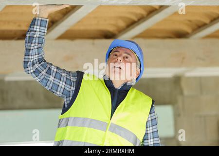 a male worker checking ceiling Stock Photo