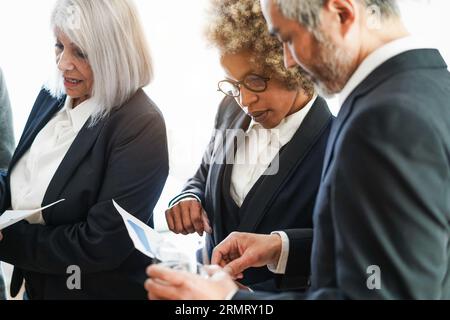 Multiracial colleagues working inside business office - Teamwork discussing about marketing strategy at workplace - Entrepreneur and brainstorm concep Stock Photo