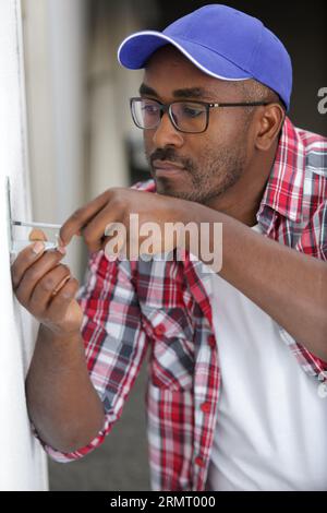 electrician checking the voltage level in wall socket cables Stock Photo