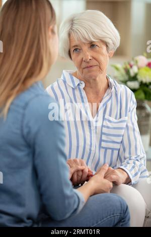 young woman comforting senior sad adult mother Stock Photo