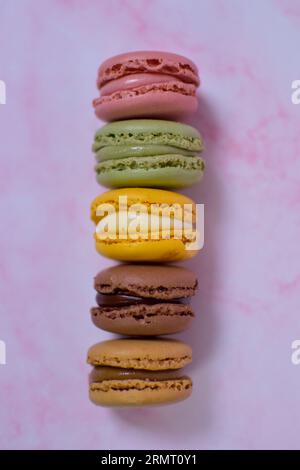 Colorful macarons stacked on pink marble Stock Photo
