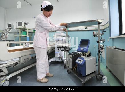 A staff tests a heart-lung machine in a negative-pressure isolation ward which can be used to accommodate Ebola virus disease (EVD) patients at Shandong Provincial Thoracic Hospital of Jinan, capital of east China s Shandong Province, Aug. 20, 2014. Authorities in Shandong recently made Shandong Provincial Thoracic Hospital the province s designated medical service institution for potential EVD cases. The hospital has taken a series of precautionary measures against the disease, which has already caused over 1,000 deaths in West Africa this year. ) CHINA-SHANDONG-JINAN-EBOLA-EVD-HOSPITAL-PRECA Stock Photo