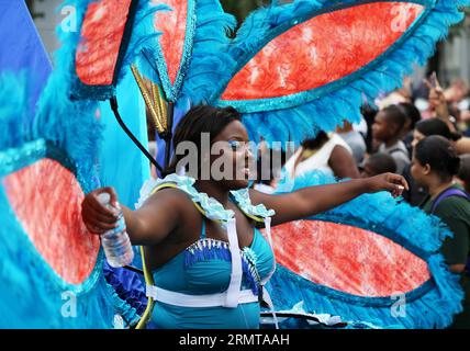 LONDON, Aug. 24, 2014 -- A performer parades through the streets during the Notting Hill Carnival in London, Britain, on August 24, 2014. The Notting Hill Carnival is the largest street festival in Europe and was first held in 1964 by the Afro-Caribbean community. Over the bank holiday weekend, the streets come alive to bands, colourful floats and costumed performers as members of the public flood into the area to join the celebrations. ) UK-LONDON-NOTTING HILL CARNIVAL-CHILDREN S DAY PARADE HanxYan PUBLICATIONxNOTxINxCHN   London Aug 24 2014 a Performer Parades Through The Streets during The Stock Photo