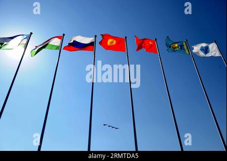 (140829) -- ZHURIHE, Aug. 29, 2014 -- Planes fly over flags of Shanghai Cooperation Organization (SCO) member countries during the closing ceremony of the Peace Mission - 2014 military drill in Zhurihe, Inner Mongolia, north China, Aug. 29, 2014. The drill, involving over 7,000 personnel from China, Russia, Kazakhstan, Kyrgyzstan and Tajikistan and expected to hone multilateral decision-making, sharpen joint anti-terror efforts and boost intelligence sharing to ensure regional peace and stability, ended here Friday along with the first edition of the SCO military tattoo. ) CHINA-INNER MONGOLIA Stock Photo