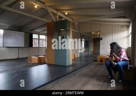 (140901) -- FRANKFURT (GERMANY), Sept. 1, 2014 -- A woman visits the exhibition room at the site of former Sachsenhausen Nazi concentration camp in Oranienburg, near Berlin, Germany, on Aug. 21, 2014. The Sachsenhausen Nazi concentration camp was built in Oranienburg about 35 km north of Berlin in 1936 and imprisoned about 220,000 people between 1936 and 1945. The site now served as a memorial and museum to learn about the history within the authentic surroundings, including the remnants of buildings and other relics of the camp. ) GERMANY-SACHSENHAUSEN CONCENTRATION CAMP luoxhuanhuan PUBLICAT Stock Photo