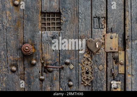 Detail of ironwork, keyplate, peep-hole, knob and studs on ancient oak door - Tours, Indre-et-Loire (37), France. Stock Photo