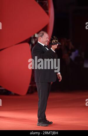 Director Roy Andersson poses with Golden Lion for Best Film he received for his movie A Pigeon Sat on a Branch Reflecting on Existence during the awards ceremony at the 71st Venice Film Festival, in Lido of Venice, Italy on Sept. 6, 2014. The Swedish film won the Golden Lion for Best Film, the highest prize awarded at the 71st Venice film festival which ended here on Saturday. ) ITALY-VENICE-FILM FESTIVAL-GOLDEN LION LiuxLihang PUBLICATIONxNOTxINxCHN   Director Roy Andersson Poses With Golden Lion for Best Film he received for His Movie a Pigeon SAT ON a Branch Reflecting ON Existence during T Stock Photo