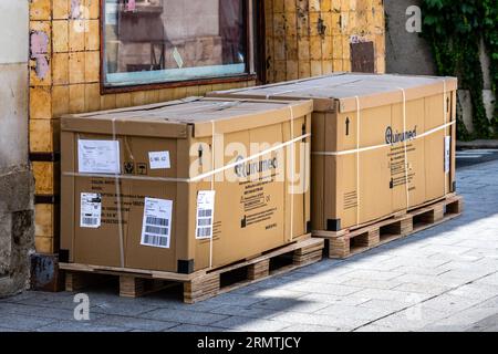 Large heavy boxes on wood pallets outside city center business - Tours, Indre-et-Loire (37), France. Stock Photo