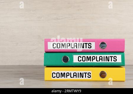 Colorful folders with Complaints labels on table, space for text Stock Photo