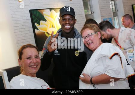 Okinawa, Japan. 30th Aug, 2023. Dennis Schröder (M) stands for a photo with two webish fans during a meeting of the German national basketball team with fans. The German basketball players enjoy a day off at the World Basketball Championships on Wednesday. Credit: Matthias Stickel/dpa/Alamy Live News Stock Photo