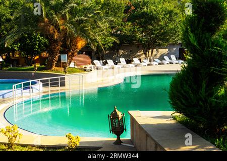 beautiful luxurious swimming pool with crystal green waters in the garden Stock Photo