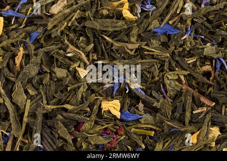 Flavoured green tea with rose petals and exotic fruits - mango, yellow peach and citrus fruits. Stock Photo