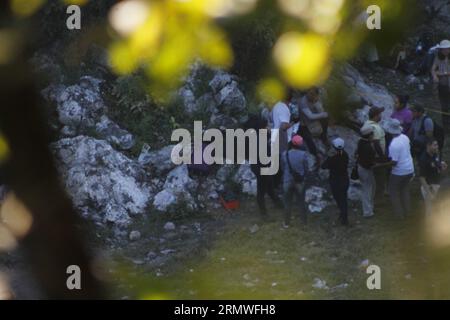 GUERRERO, Oct. 27, 2014 -- People wait in the place where elements of the Ministerial Police of the Attorney General s Office (PGR, for its acronym in Spanish), guard the site close to the municipal landfill of Colula, in Guerrero state, Mexico, on Oct. 27, 2014. Experts of the PGR and members of the Mexican Army discovered on Monday a clandestine pit in the municipal landfill of Cocula, Guerrero, Mexico, in wich they are working to determine if there are human remains, according to local press. Mexican President Enrique Pena Nieto instructed the Security Cabinet to meet with Guerrero s Acting Stock Photo