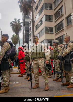 Lima, Peru - July 29 2023: Young Peruvian Man with Black and Green Face Paint, Wearing Camouflage Clothing and a Bulletproof Vest, Poses to the Camara Stock Photo