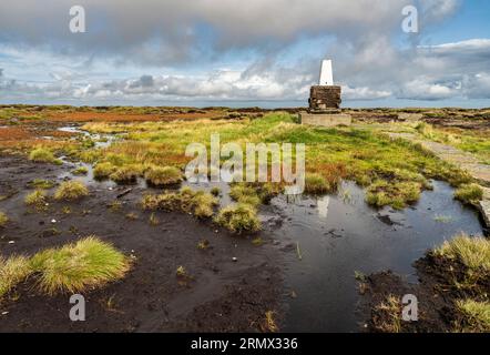 Triangulation pillar (trig point) on the blanket bog summit of The Cheviot, 815m) Northumberland National Park Stock Photo