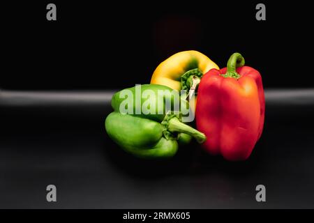 different colored peppers on black background Stock Photo