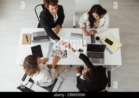 Top view of diverse businesspeople shaking hands after sealing a deal, concluding business agreement Stock Photo