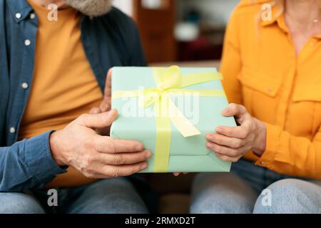 Cropped of senior couple exchanging presents on anniversary at home Stock Photo