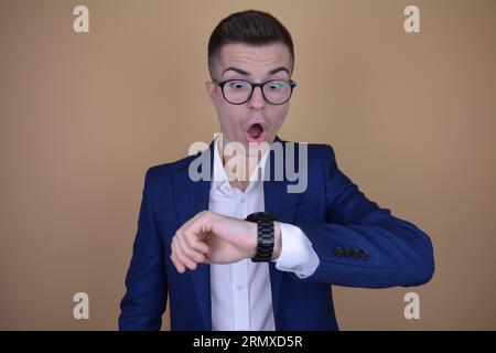 Shocked Young Handsome Elegant Man Checking Time on His Watch on Isolated Background Stock Photo