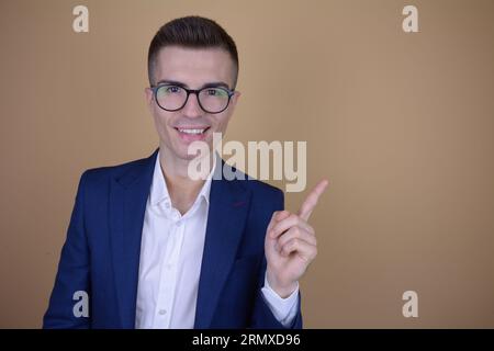 Smiling Young Handsome Elegant Man Pointing Upward on Isolated Background Stock Photo