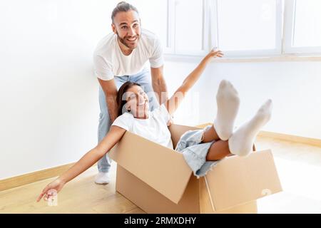 Playful multiracial couple having fun in home on relocation day Stock Photo