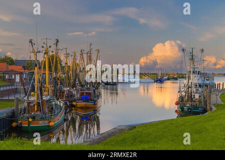 An evening photo of the picturesque harbor in the fishing village of Greetsiel. Greetsiel is a small harbor town on the Leybocht in the west of East F Stock Photo