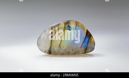 Polished Labradorite Mineral Gem Stone with Blue and Yellow Iridescence on Grey Background Stock Photo