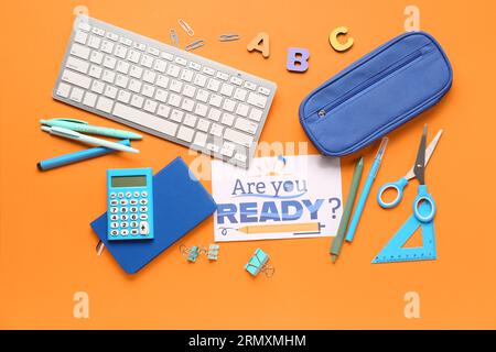 Card with question ARE YOU READY?, stationery and keyboard on orange background Stock Photo