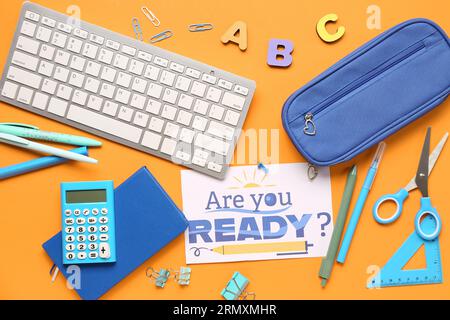 Card with question ARE YOU READY?, stationery and keyboard on orange background Stock Photo