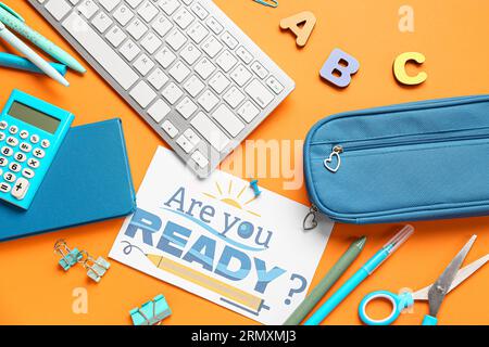 Card with question ARE YOU READY?, stationery and keyboard on orange background Stock Photo