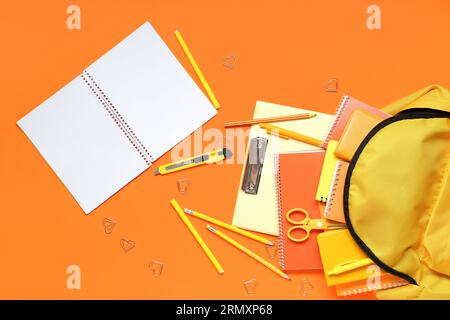 Stylish school backpack and different stationery on orange background Stock Photo