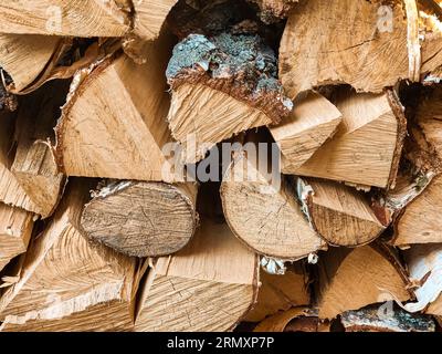 Chopped firewood is stacked in neat piles. Woodpile. Background. Close-up. Selective focus. Stock Photo