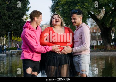 three friends laughing and playing with each other, having fun and having good time in public park, people and inclusion concept, copy space. Stock Photo