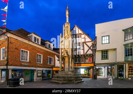 Evening view of the medieval Buttercross Monument at Market Square and High Street in the historic city of Winchester, UK. Stock Photo