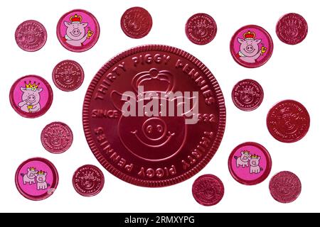 Percy Pig pennies fruit flavoured chocolate pennies from M&S isolated on white background - ten five and thirty piggy pennies 10p 5p Stock Photo