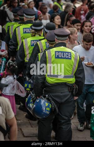 Police move through the crowds at the Notting Hill Carnival in London. Stock Photo