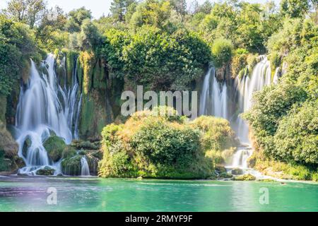 Kravica karst forest waterfall flows with lake in the foreground, Trebizat river, Bosnia and Herzegovina Stock Photo