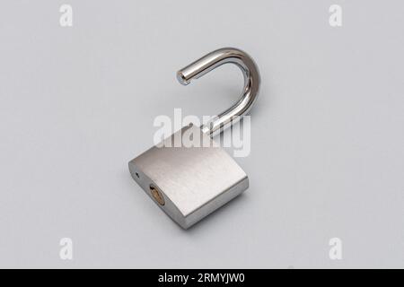 Unlocked silver padlock on the gray background. Stock Photo